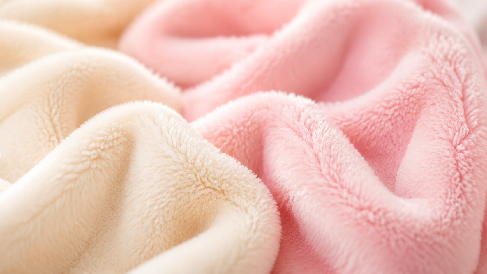 Macro close-up of ultra-soft Minky plush fabric with a buttery smooth texture in pastel pink and beige colors for premium stuffed animals.